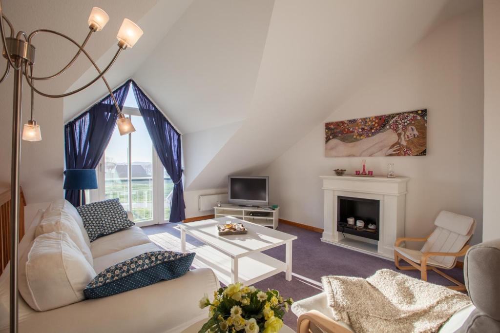 Una sala de estar con un sofá y una chimenea. en Ellerüher Weg Maisonette, en Kappeln