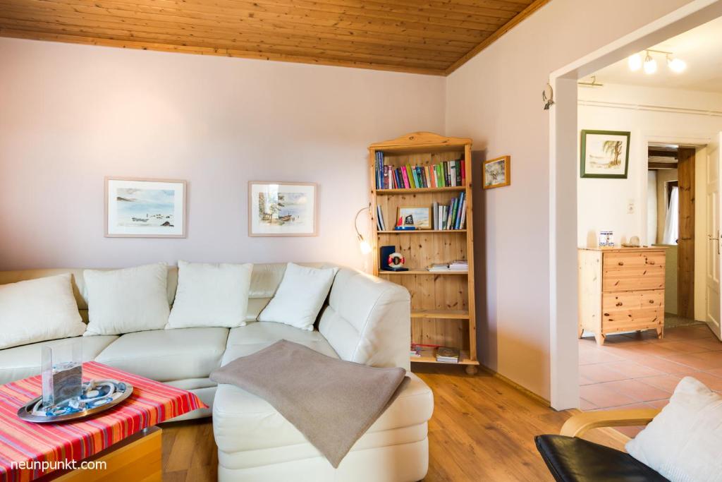 a living room with a white couch and a book shelf at Falshöft 1a in Nieby