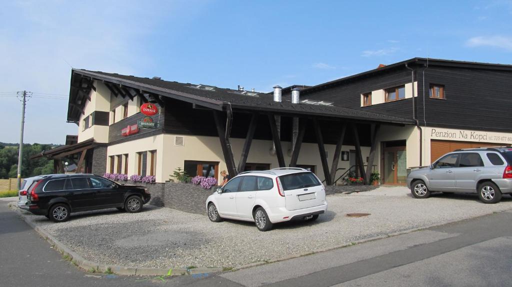 three cars parked in front of a building at Penzion Na Kopci Vřesina in Vřesina