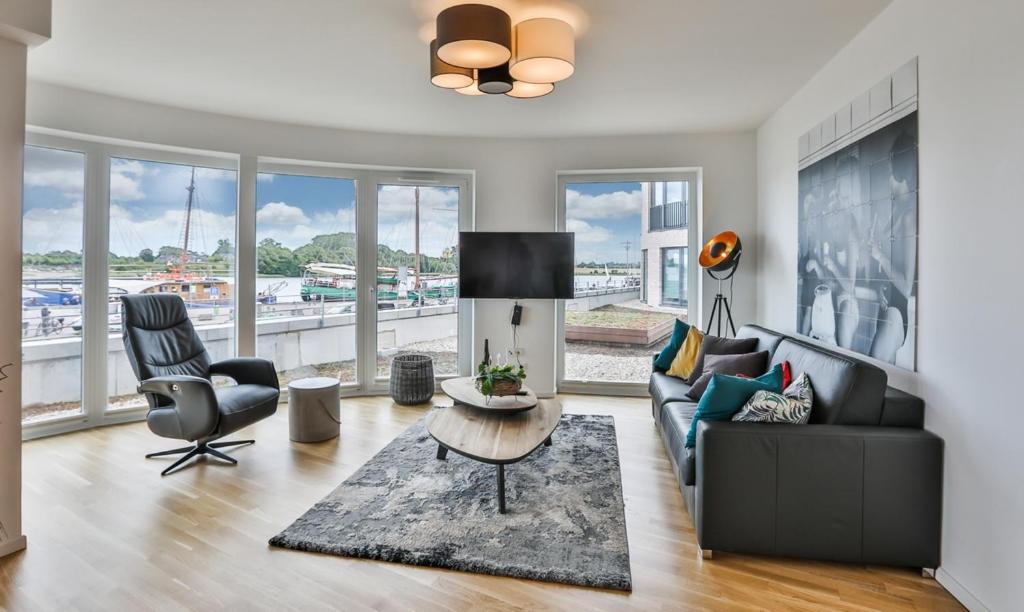 een woonkamer met een bank, een tafel en stoelen bij Küstennebel - D2 in Kappeln