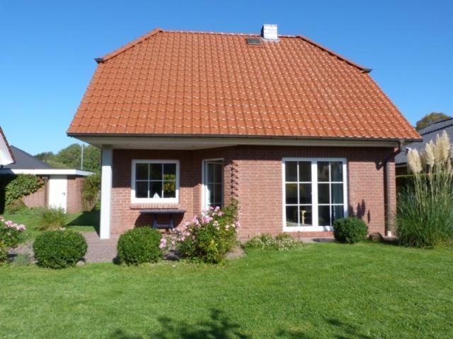 a small brick house with an orange roof at Schmiedekoppel in Kronsgaard