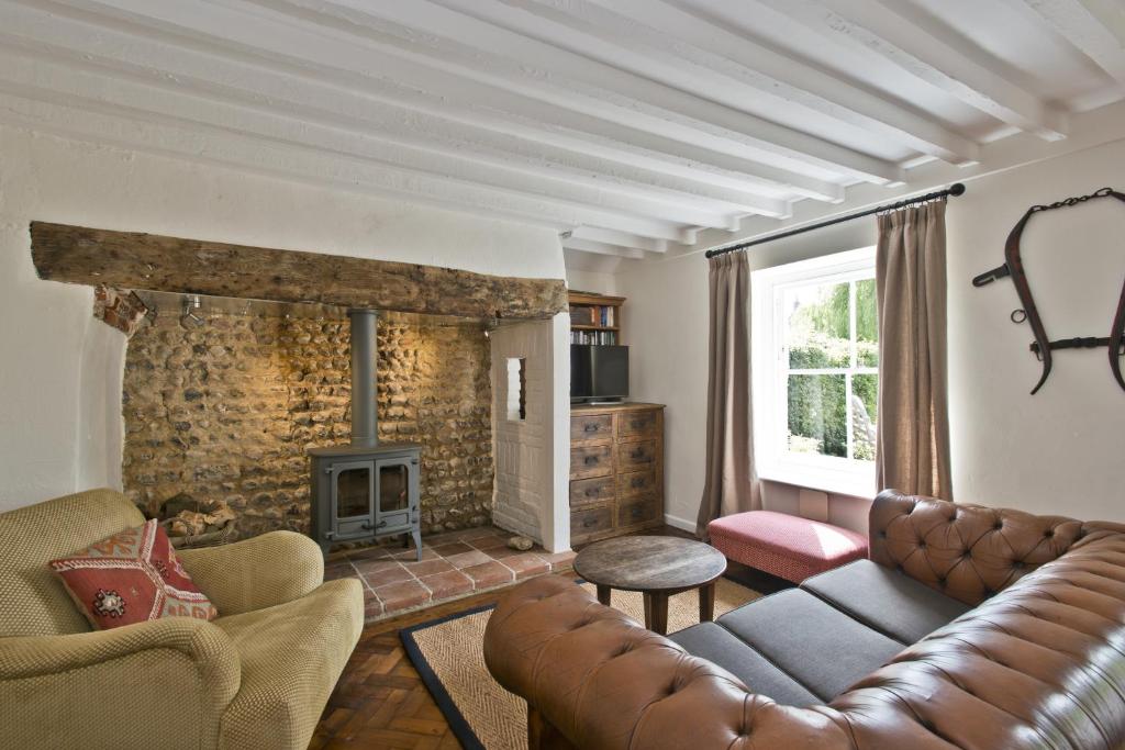 a living room with a couch and a fireplace at Japonica Cottage in East Rudham