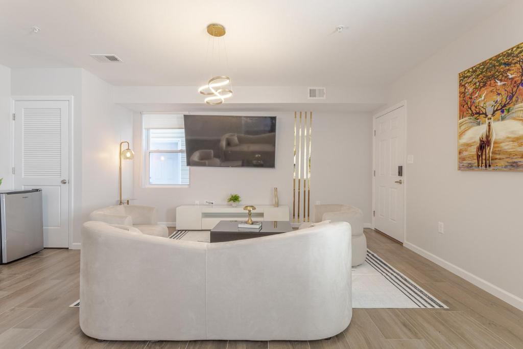 a white living room with a large white couch at Modern one bedroom apartment in Elizabeth