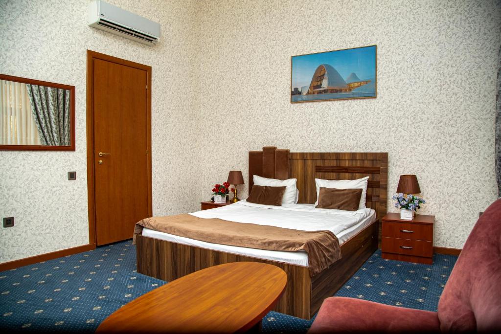 Habitación de hotel con cama y silla en Du Port Boutique Hotel en Baku