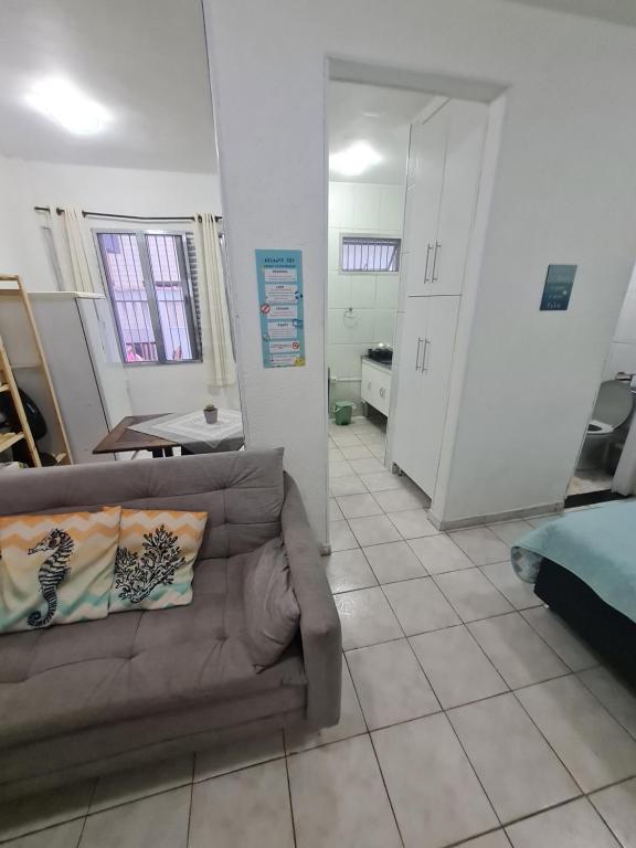 a living room with a couch on a tiled floor at Recanto 101 in Praia Grande