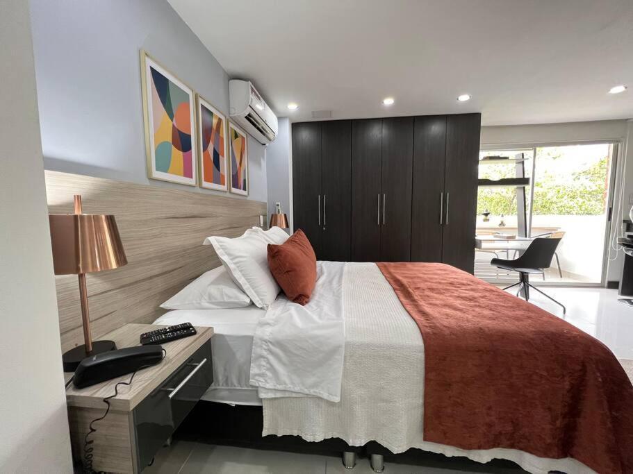 een slaapkamer met een groot bed, een bureau en een bureau bij Aparta Loft La Frontera Poblado in Medellín