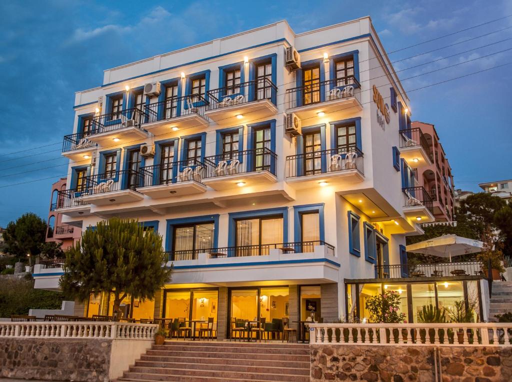 a large white building with stairs in front of it at Sun Hotel in Çeşme