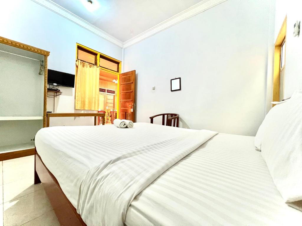 una camera con un grande letto bianco di Wisma Mutiara a Padang