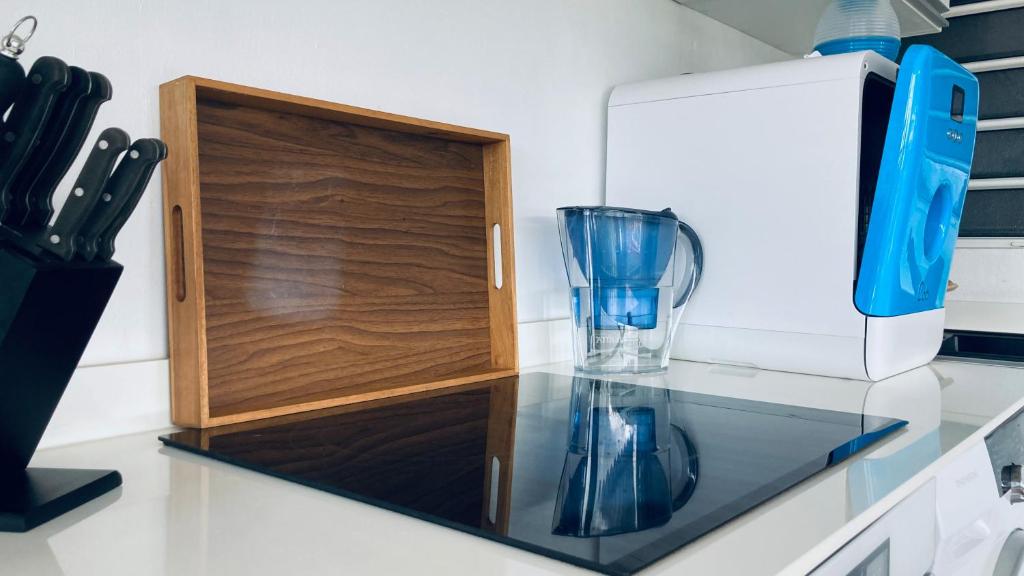 a kitchen counter with a glass cabinet and a cup at Duplex à 50m de la plage du Diamant avec parking in Le Diamant