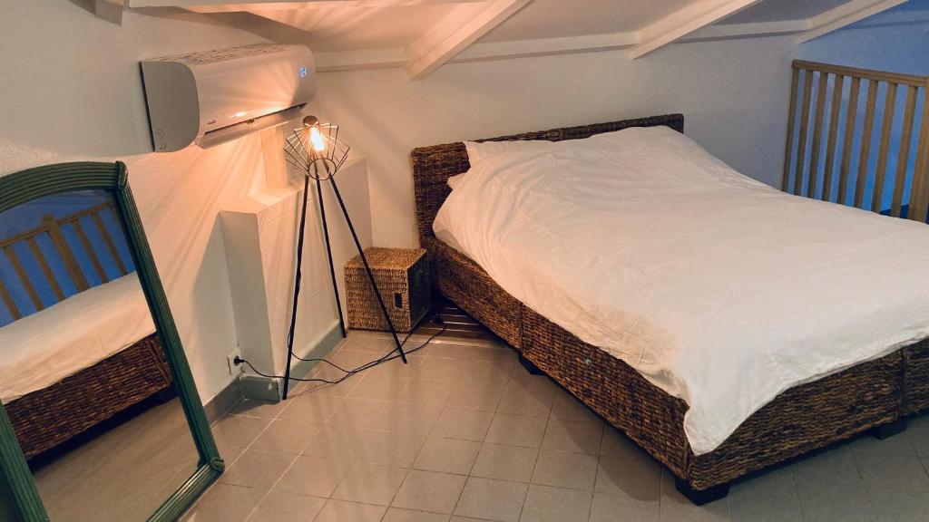a bedroom with a bed with a light and a lamp at Duplex à 50m de la plage du Diamant avec parking in Le Diamant