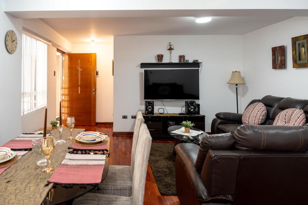 ein Wohnzimmer mit einem Sofa und einem Tisch in der Unterkunft Aura Apartamento Cusco in Cusco