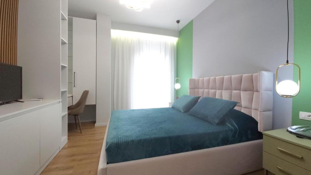 een slaapkamer met een bed, een bureau en een televisie bij 999 Apartments in Tirana