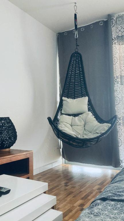 a hammock hanging in a room with a bed at Duplex à 50m de la plage du Diamant avec parking in Le Diamant