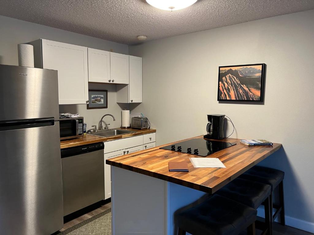 a kitchen with a refrigerator and a wooden counter top at The Pioneer Studio at 1400K in Anchorage