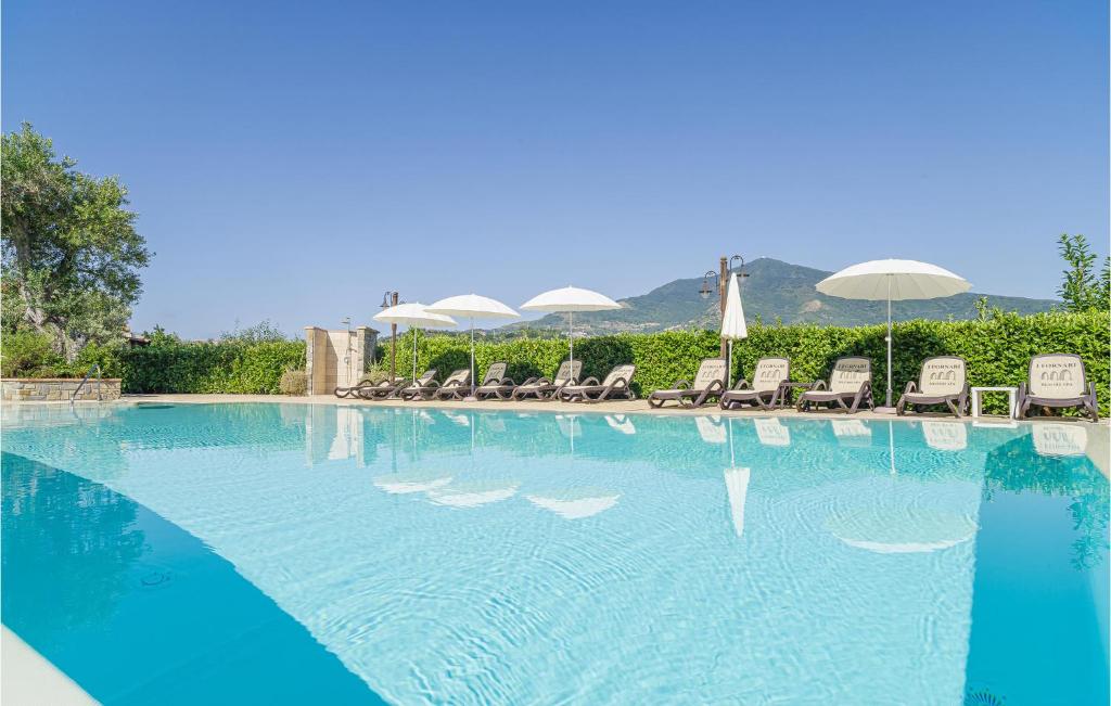 una gran piscina con sillas y sombrillas en Pet Friendly Home In Stella Cilento With House A Panoramic View, en Stella Cilento