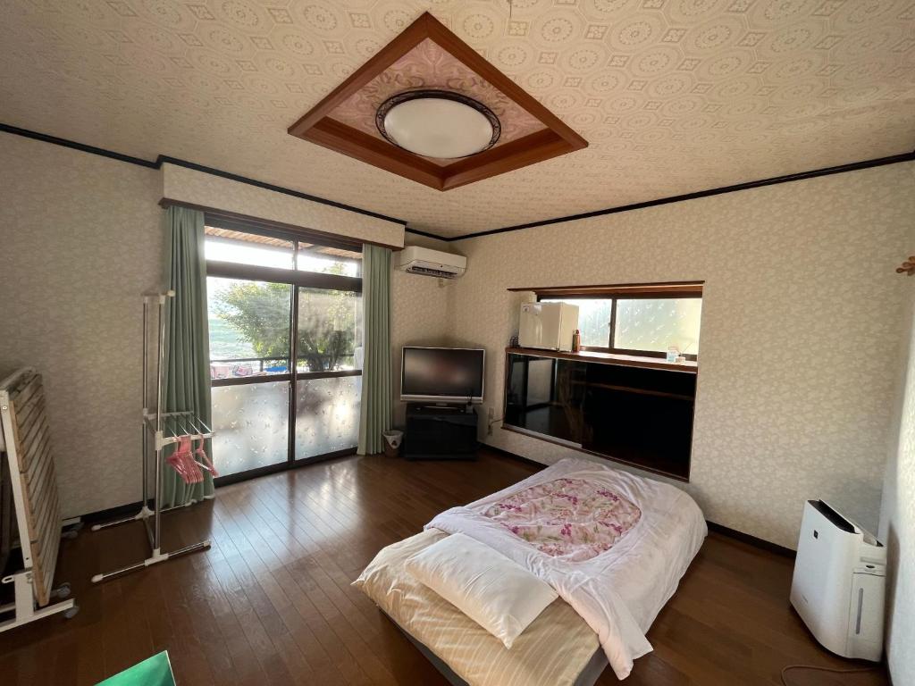 人吉的住宿－Guest house HEART - Vacation STAY 04626v，一间卧室设有一张床、一台电视和一个窗口。