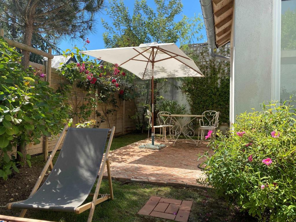 patio z parasolem, krzesłem i stołem w obiekcie Villa calme et spacieuse près de la plage, avec jardin et WIFI à Villers-sur-Mer - FR-1-712-53 w mieście Villers-sur-Mer