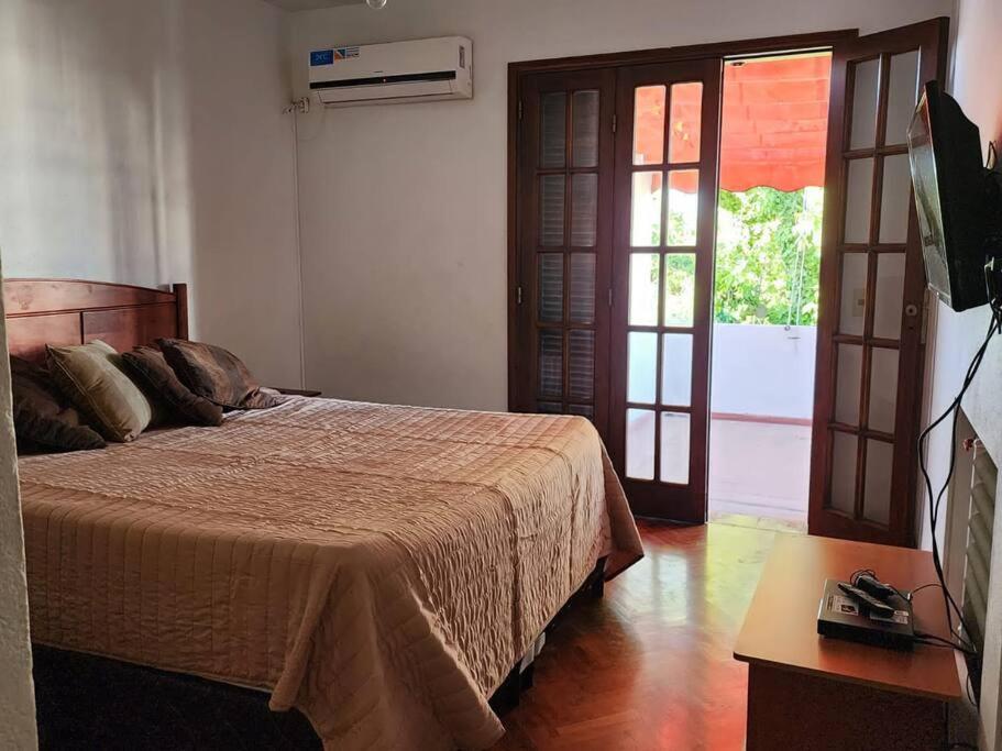 a bedroom with a bed and a sliding glass door at Viajar y sentirse en casa! in Mendoza