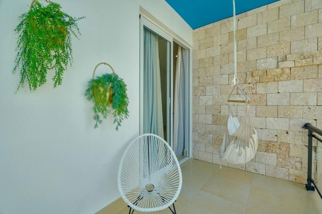 Cette chambre dispose d'un ventilateur blanc et d'un mur en briques. dans l'établissement SWEET DREAM VILLA, à Punta Cana