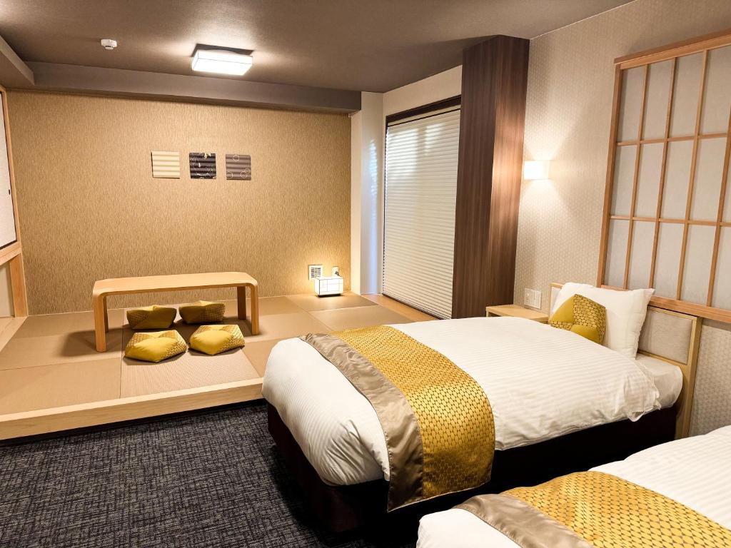 a hotel room with two beds in a room at Rinn Kyoto Station West in Kyoto