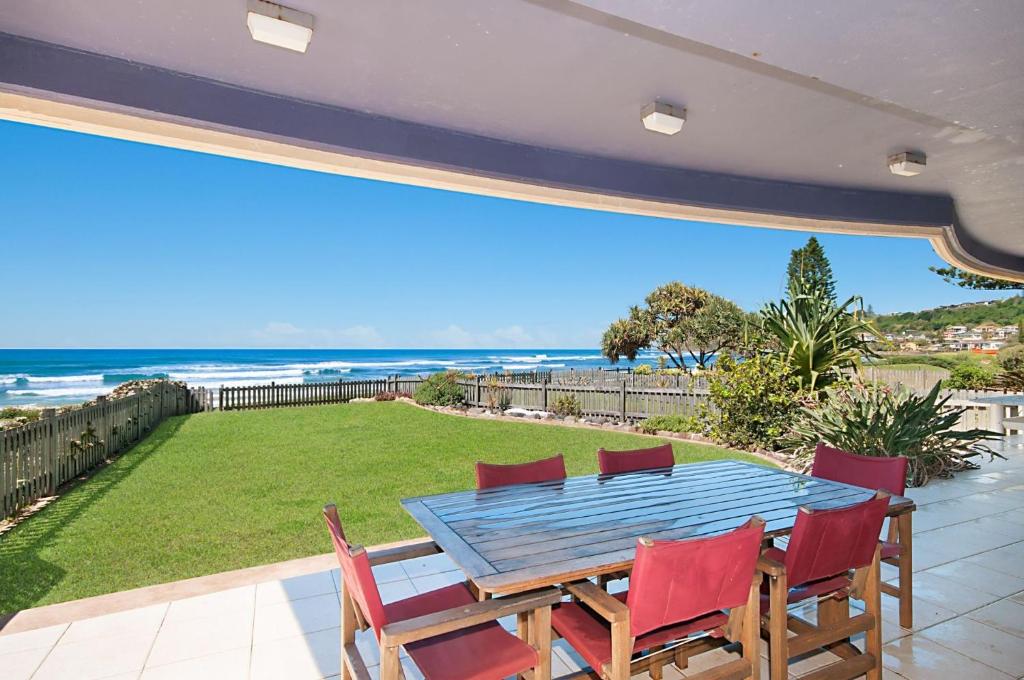 a table and chairs on a patio with a view of the ocean at Portofino in Lennox Head