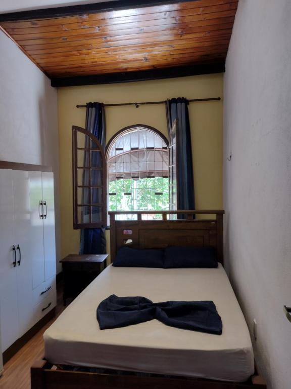 Un dormitorio con una cama con una pajarita. en Casa Familiar Colombia, en São Paulo