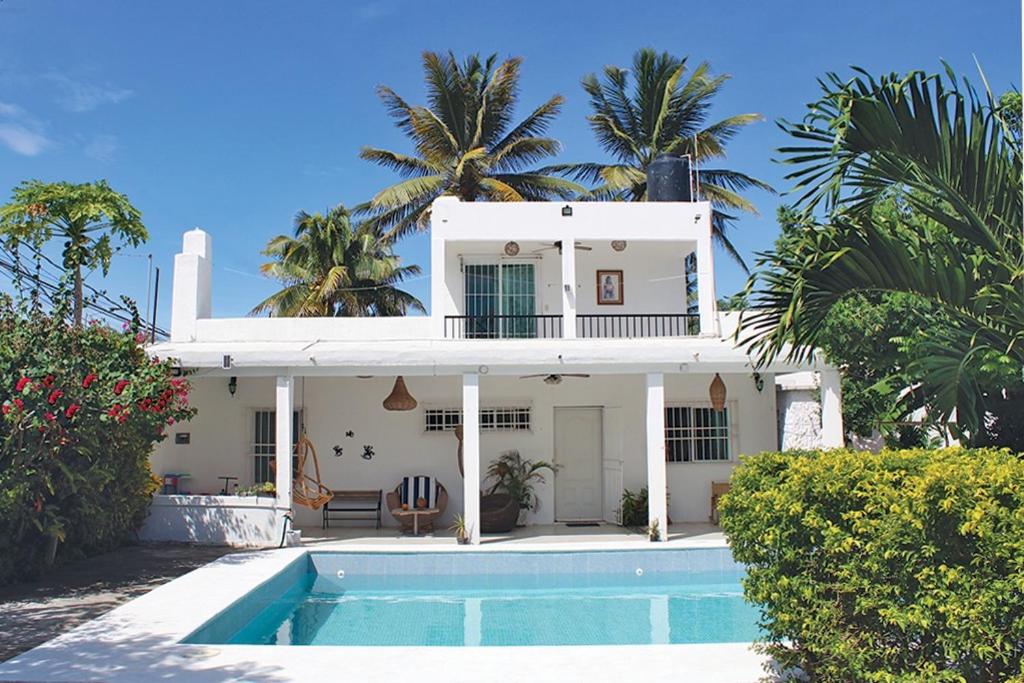 een wit huis met een zwembad ervoor bij CASA CHACHALACAS in Chachalacas