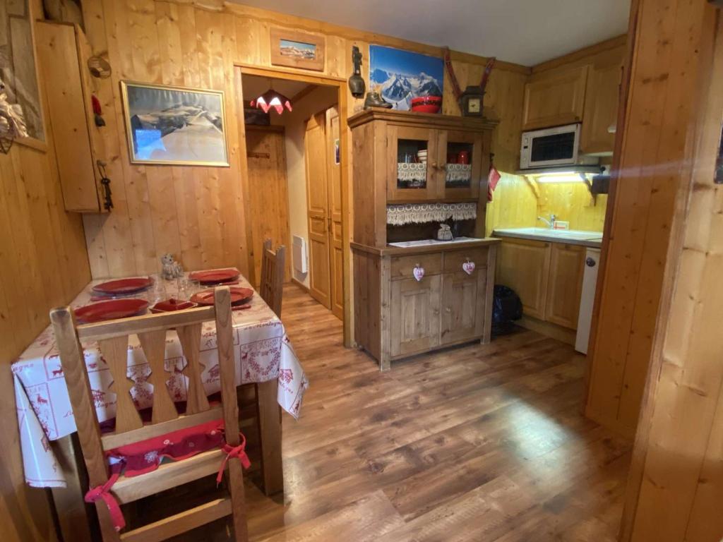 a kitchen with a table in a room with wooden floors at Appartement Praz-sur-Arly, 2 pièces, 4 personnes - FR-1-603-83 in Praz-sur-Arly