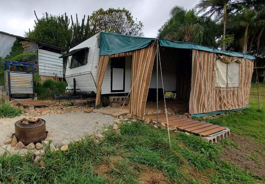 una cabaña con una tienda en un patio en Private Caravan and facilities - Tarzali Valley Veiws, en Tarzali