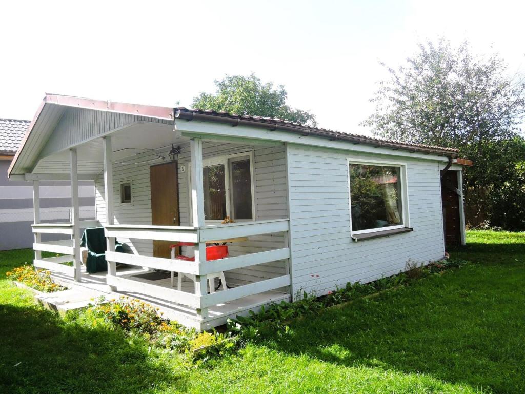 uma pequena casa branca num quintal em Bungalow with terrace, Wrzosowo em Wrzosowo