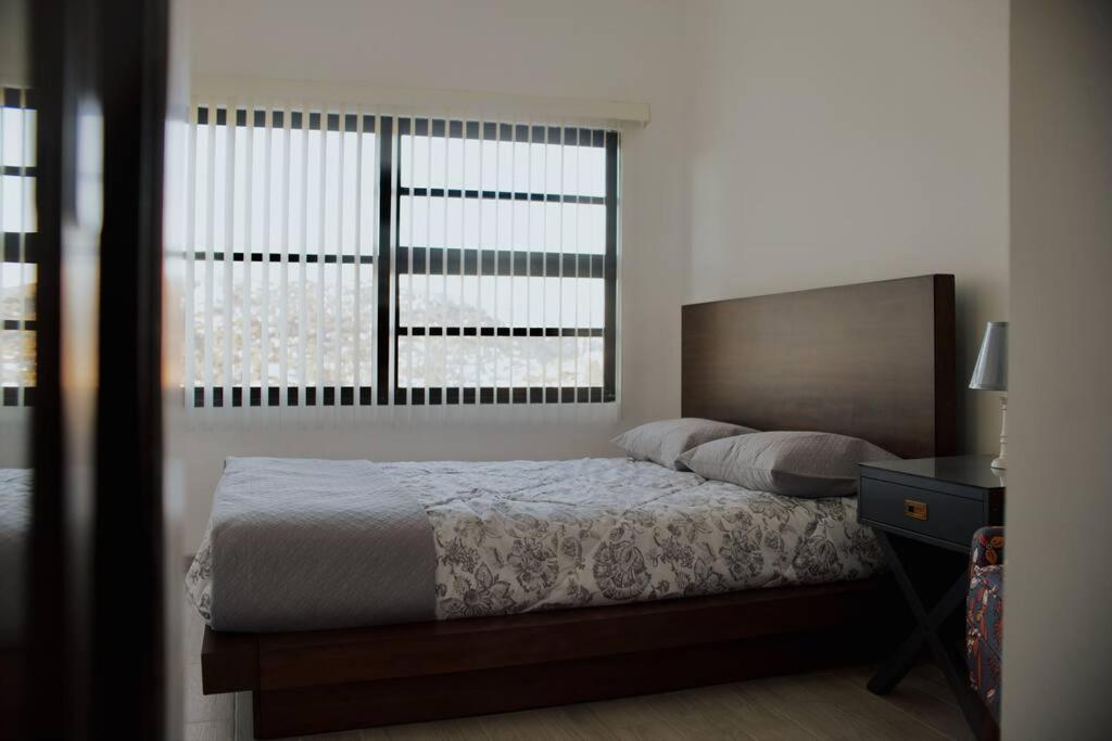 a bedroom with a bed and a large window at Macfarland Suites in Ensenada