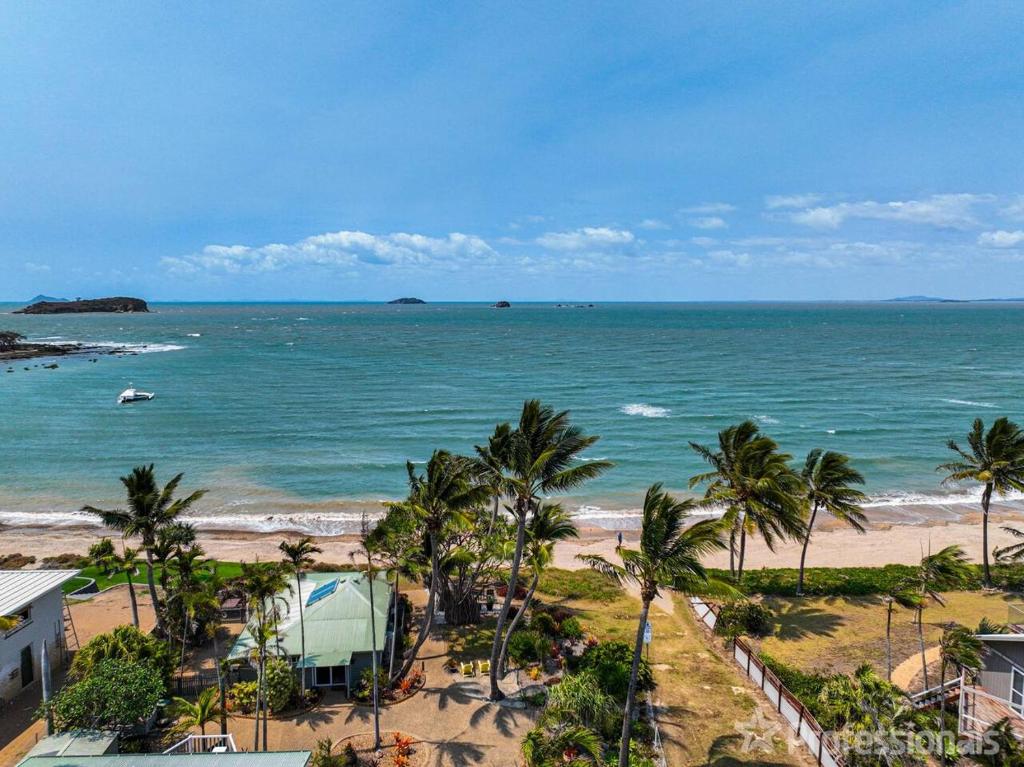 a view of a beach with palm trees and the ocean at Beachfront Holiday House in Zilzie