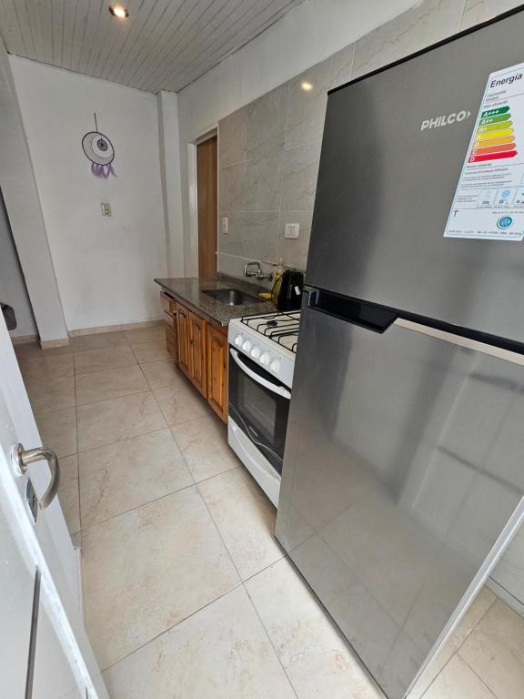 a kitchen with a stainless steel refrigerator and a stove at Departamento Pbaja centro Mendoza in Las Heras