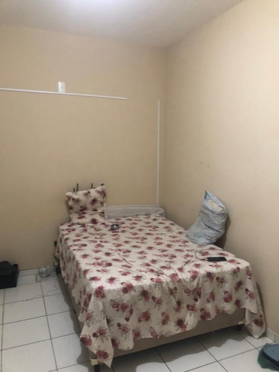 ein Schlafzimmer mit einem Bett mit einer Blumendecke in der Unterkunft SamazzHouse in Guanambi