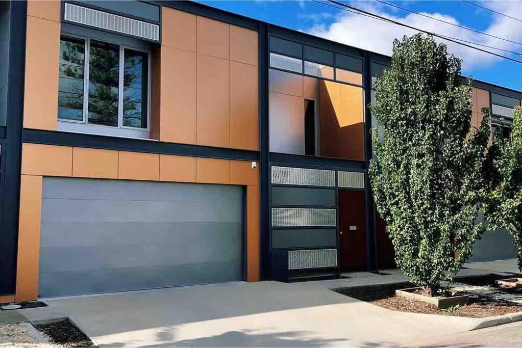 a house with two garage doors and a tree at Inner City Stay Mildura in Mildura