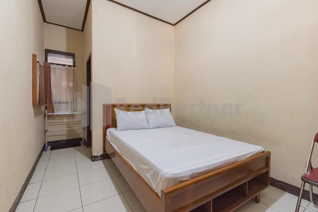 a small bedroom with a bed in a room at Homestay PKPN Garut Mitra RedDoorz in Garut