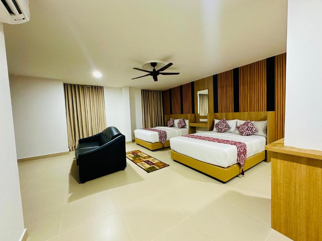 A spacious-looking twin room with a sofa, ceiling fan and curtained window.