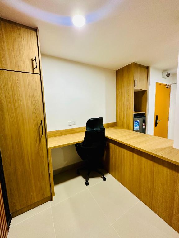 A built-in corner desk with an office chair inside a wood-panelled room.