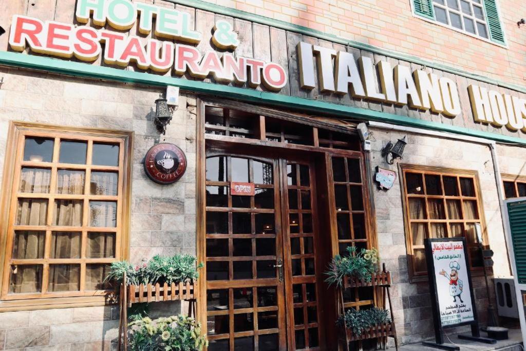 a restaurant with a sign on the front of a building at Italian House in Baghdād