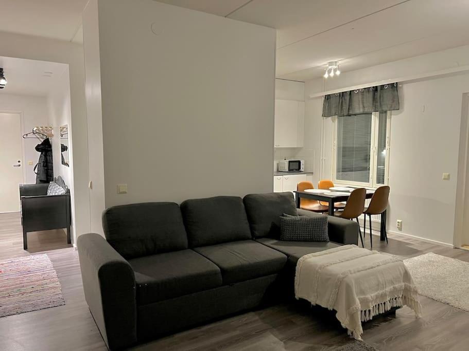 a living room with a black couch and a table at Apartment Korsholma1 in Vaasa