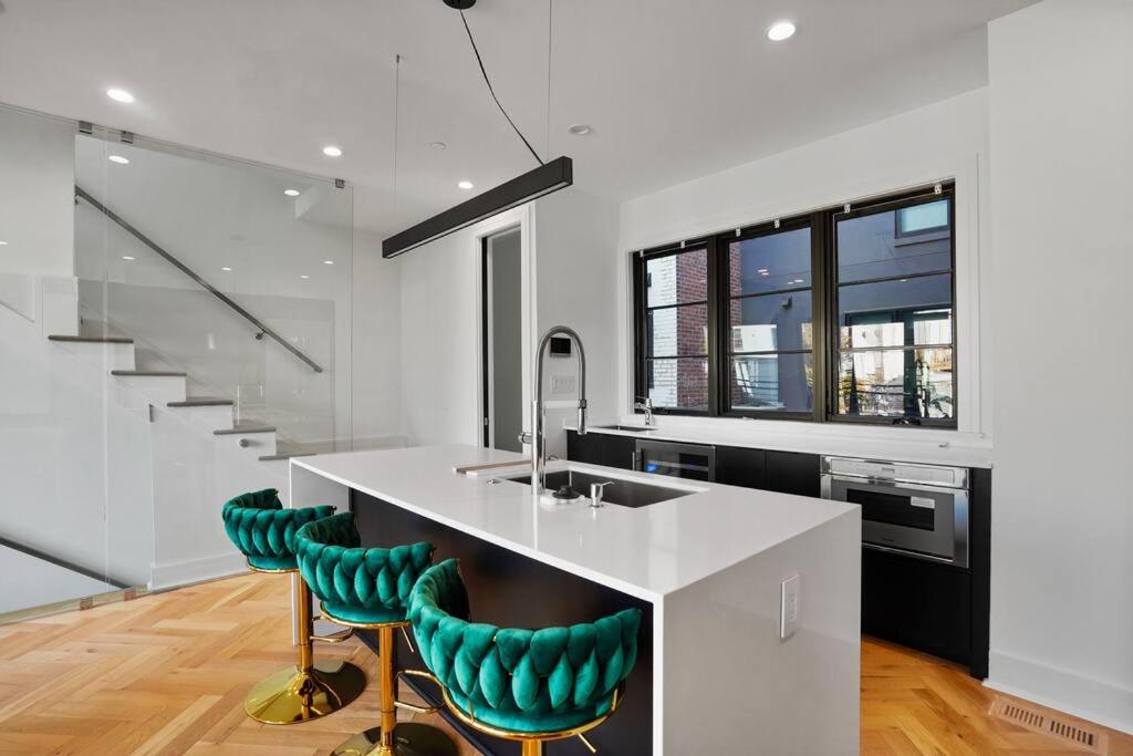 a kitchen with a white island with green bar stools at Central DC Home+Private Rooftop! (Unit B) in Washington