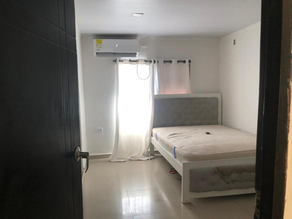 Habitación pequeña con cama y ventana en Apartamentos de lujo puerto Colombia el encanto, en Puerto Colombia