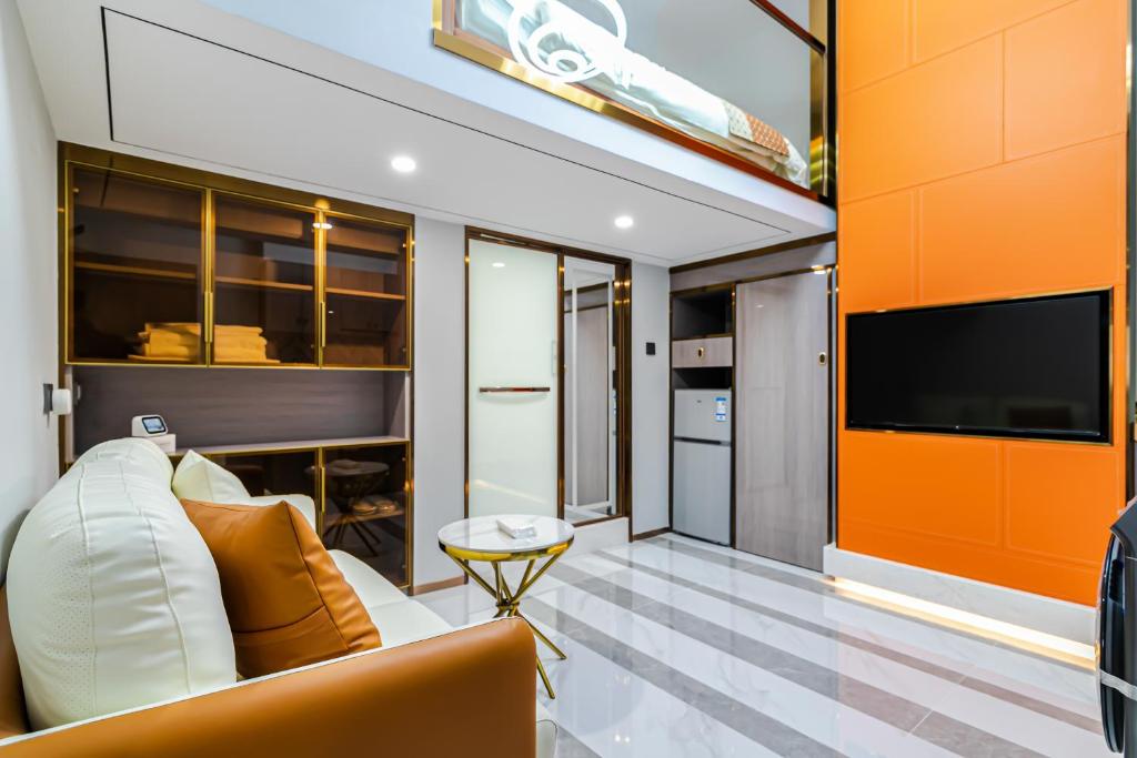 Yunga Yee Tsui Apartments云嘉倚翠公寓 في قوانغتشو: غرفة معيشة مع أريكة وتلفزيون