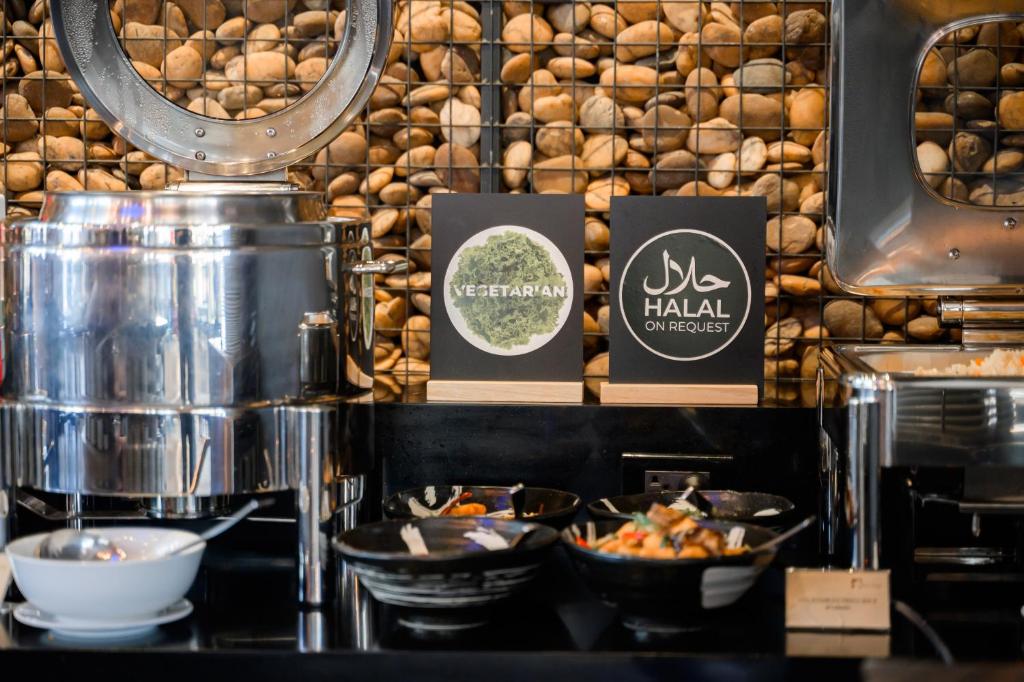 a bakery with bowls of food on a counter at Hotel Clover Asoke - SHA Extra Plus in Bangkok