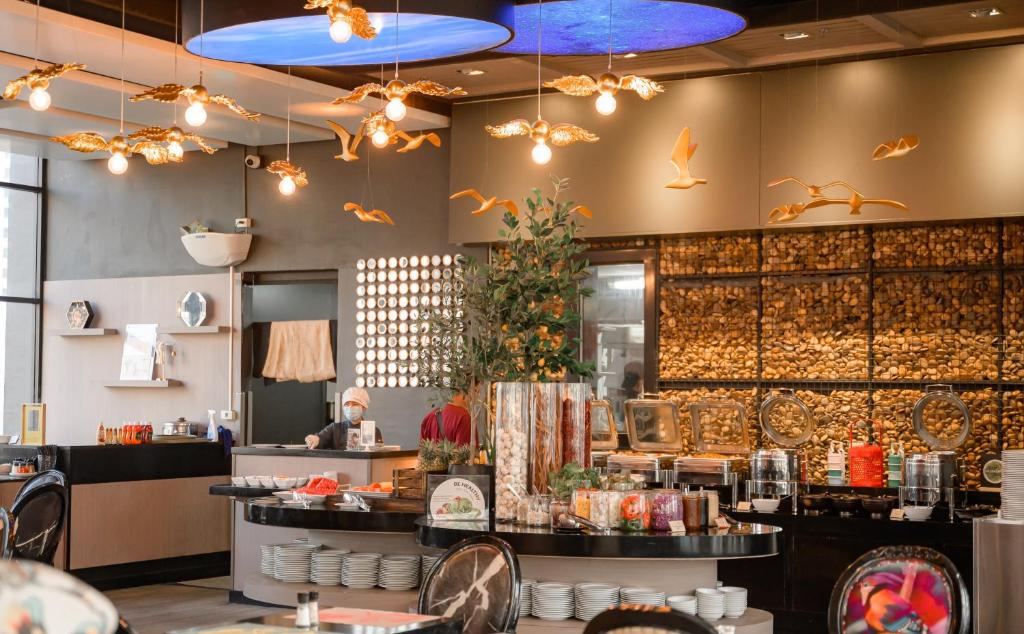 a restaurant with tables and chairs and lights at Hotel Clover Asoke - SHA Extra Plus in Bangkok