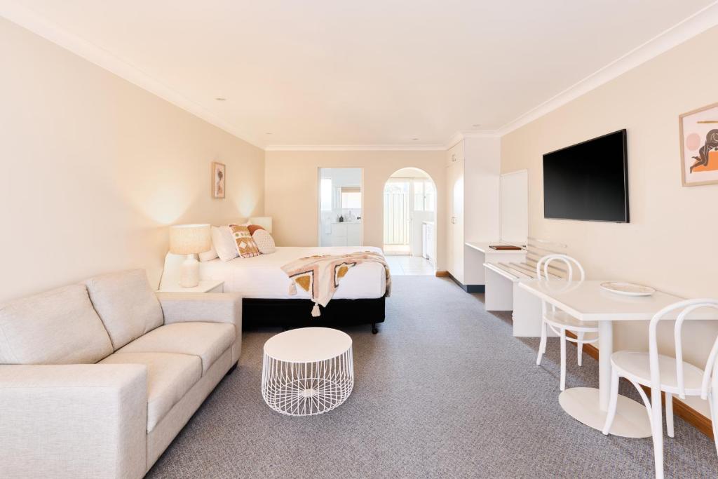 a hotel room with a bed and a couch at Harbourview House in Bermagui