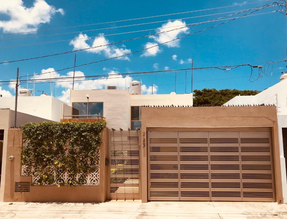 uma casa com uma porta de garagem em frente em Habitación independiente al Norte de Mérida em Mérida
