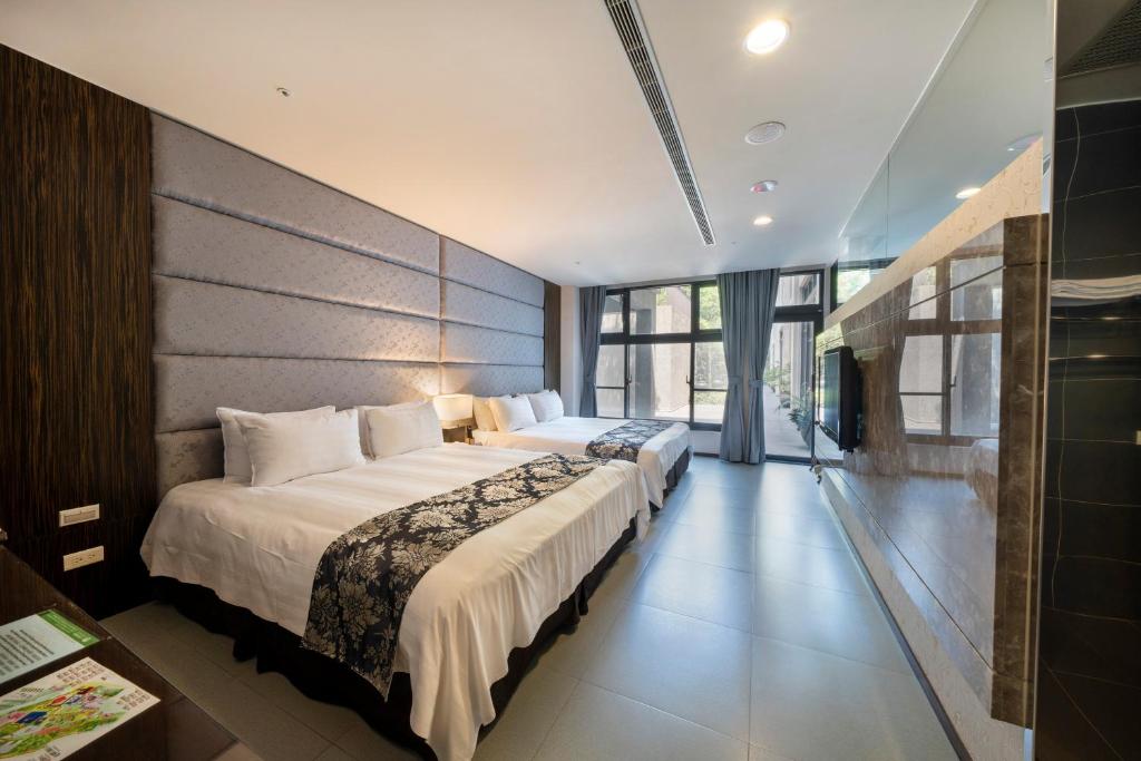 a bedroom with two beds and a large window at Tai-Yi Red Maple Resort in Puli