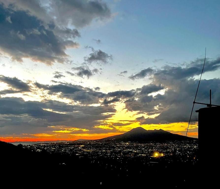 un coucher de soleil sur une ville avec une montagne en arrière-plan dans l'établissement B&B Donna Francé, à Corbara