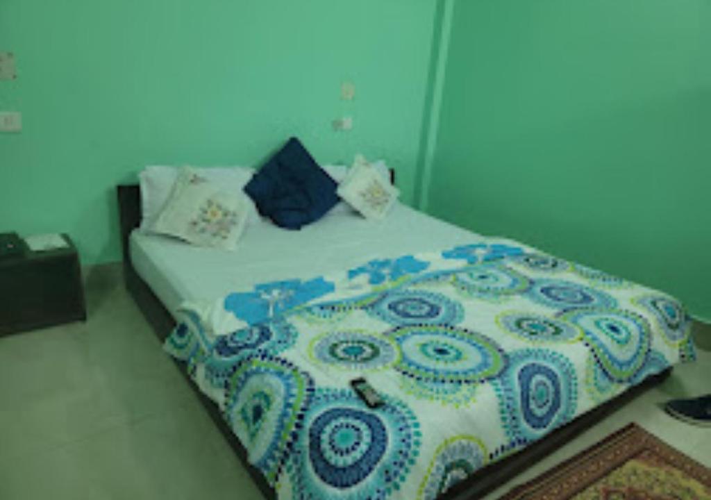 Schlafzimmer mit einem Bett mit blauer und weißer Bettwäsche in der Unterkunft Hotel Mandal Ghang Arunachal Pradesh in Bhalukpung